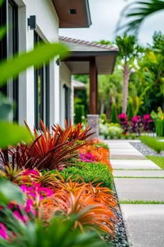 an outdoor garden with colorful flowers and plants in the foreground, next to a house