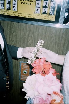 a man in a suit and tie is handing money to a woman's hand