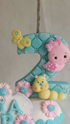 a cake shaped like the number one for a baby's first birthday decorated with fondant