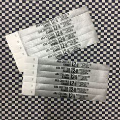 four tickets are sitting on top of a checkered tablecloth with black and white numbers