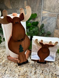 two wooden deer figurines sitting on top of a counter