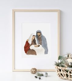 the birth of jesus is framed in a white frame next to some christmas decorations and ornaments