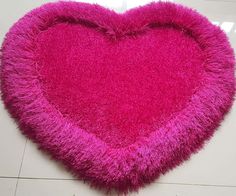 a pink heart shaped rug on the floor