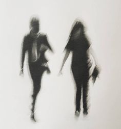 two people are walking down the street in black and white