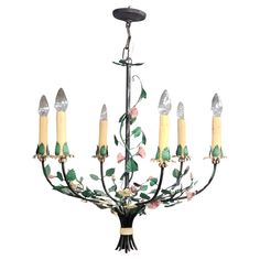 a chandelier with six candles and flowers on it