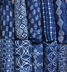 many different types of blue and white fabrics are stacked up on top of each other