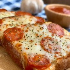 two slices of pizza sitting on top of a wooden cutting board