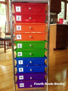 a stack of colorful drawers sitting on top of a hard wood floor