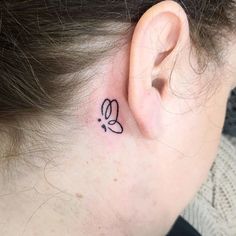 a woman's ear with a small tattoo on it