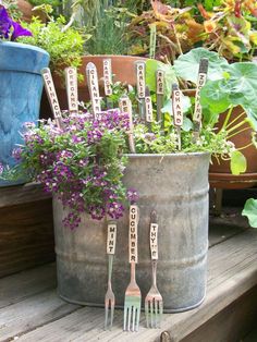 garden utensils are sitting in a bucket with flowers