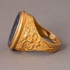 This decadent intaglio ring captures the enigmatic allure of Hades, the god of the underworld, masterfully carved into a deep blue man-made sapphire, a gem as rich as the mythical treasures he guards. Set in a band of polished 18K gold, this ring is a portal to antiquity, a luxurious tribute to the ruler of shadows and wealth. It's a powerful emblem of dominion and mystery, inviting those who wear it to wield their influence with the quiet confidence of the gods. Materials: Man-made blue sapphir Luxury Carved Yellow Gold Signet Ring, Luxury Ceremonial Signet Ring With Intaglio, Luxury Engraved Sapphire Ring, Luxury Oval Engraved Carved Ring, Luxury Intaglio Rings For Collectors, Elf Oc, Wax Jewelry, Intaglio Ring, God Of The Underworld