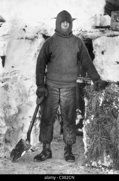 an old black and white photo of a man standing in the snow