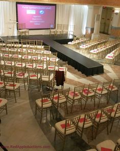 rows of chairs are set up in front of a projector screen for an event