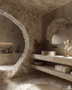 a bathroom with two round mirrors above the sinks and towels on the counter next to it