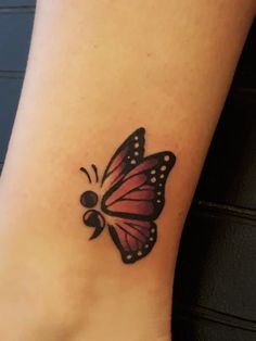 a small butterfly tattoo on the ankle