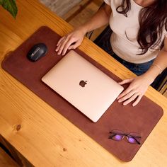 a woman sitting at a table with an apple computer