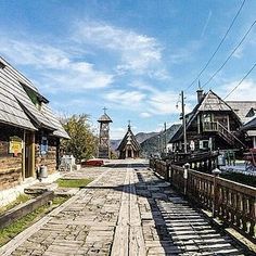 an old town street with wooden buildings and cobblestone walkways on both sides