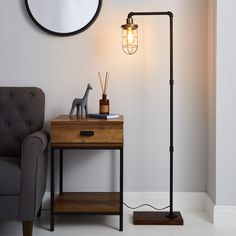 a living room with a chair, lamp and mirror on the wall next to it