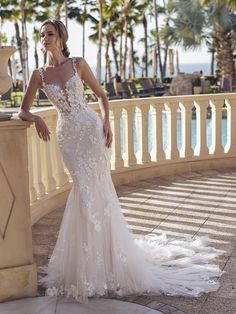 a woman in a wedding dress standing on a balcony