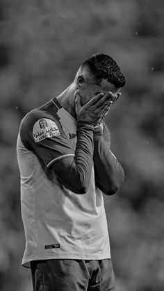 a black and white photo of a man holding his hands to his face as if praying