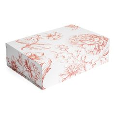 a white box with red floral designs on the lid and bottom, sitting on a white surface