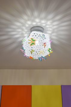 the ceiling light is brightly colored and has many small beads on it's surface