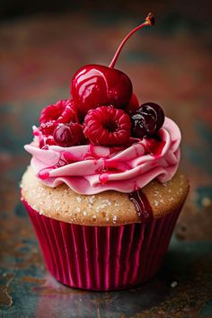 a cupcake with pink frosting and cherries on top