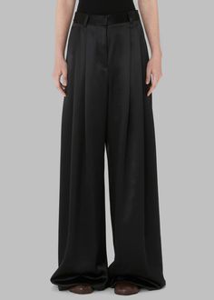 Color: Black Lightweight satiny fabric Relaxed fit Wide leg High rise Pleated detailing Side seam pockets Illusion welt back pocket Belt loops Zip fly Interior button closure Hook and bar closure Partially lined 100% Polyester Dry Clean By JW Anderson. Made in Bulgaria Black Silk Wide-leg Pants, High Waist Satin Wide Leg Pants For Work, Sleek Satin Pants For Work, High Waist Silk Wide Leg Pants For Work, Satin Pants For Workwear, Black Silk Wide Leg Bottoms, Silk Straight Pants In Solid Color, Sleek Wide-leg Silk Pants, Satin Wide Leg Pants For Workwear