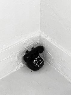 a black and white photo of a pair of shoes on the floor in a corner