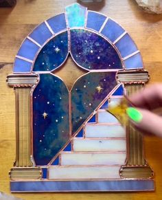 a stained glass window is being worked on by someone using a paintbrush and glue