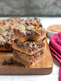 three pieces of dessert sitting on top of a wooden cutting board