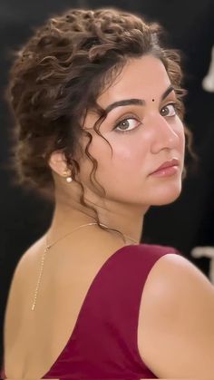 a woman with curly hair wearing a red dress