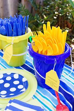 a table topped with plates and cups filled with plastic utensils