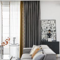 a living room filled with lots of furniture next to a tall white window covered in curtains