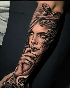 a woman's arm with a snake on it and yellow eyes in the background