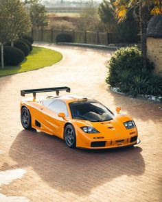 an orange sports car is parked in the driveway