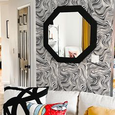 a living room filled with furniture and a large mirror on the wall over a white couch