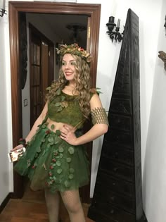 a woman in a green costume standing next to a mirror with her hands on her hips