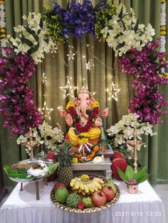 there is a statue of lord ganesh in front of some flowers and fruit on the table