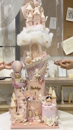 there is a pink castle cake on display in the store with people standing around it