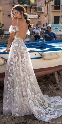 a woman in a white dress standing next to a boat