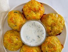 a white plate topped with food next to a cup of ranch dressing on top of it