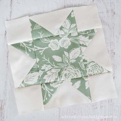 a green and white quilted star sitting on top of a wooden table