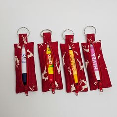 four red zippered pens are lined up next to each other