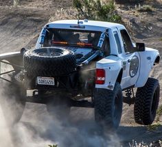 a white truck driving down a dirt road