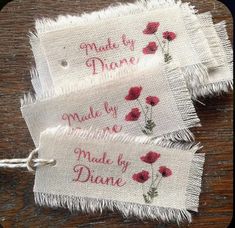 two embroidered tags with red flowers on them