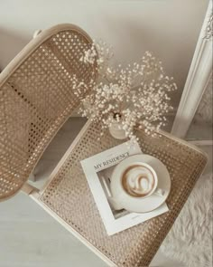 a cup of coffee sitting on top of a wicker table