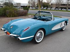 a blue and white convertible car parked on the street