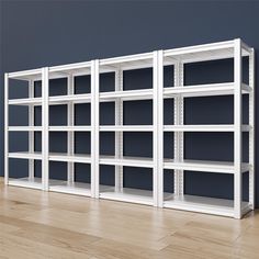 several white shelving units lined up against a wall in an empty room with hard wood flooring