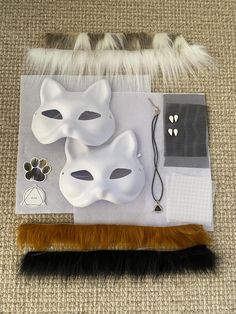 two white masks on top of a piece of paper and some furry material next to it